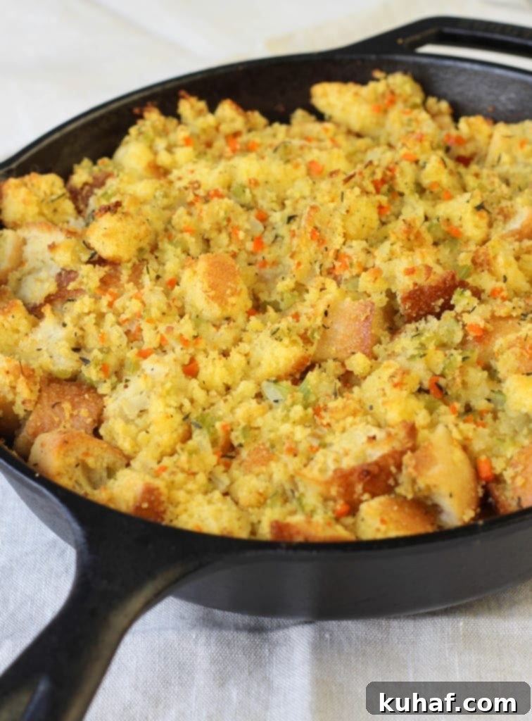 Close-up of golden brown cornbread stuffing in a white baking dish.
