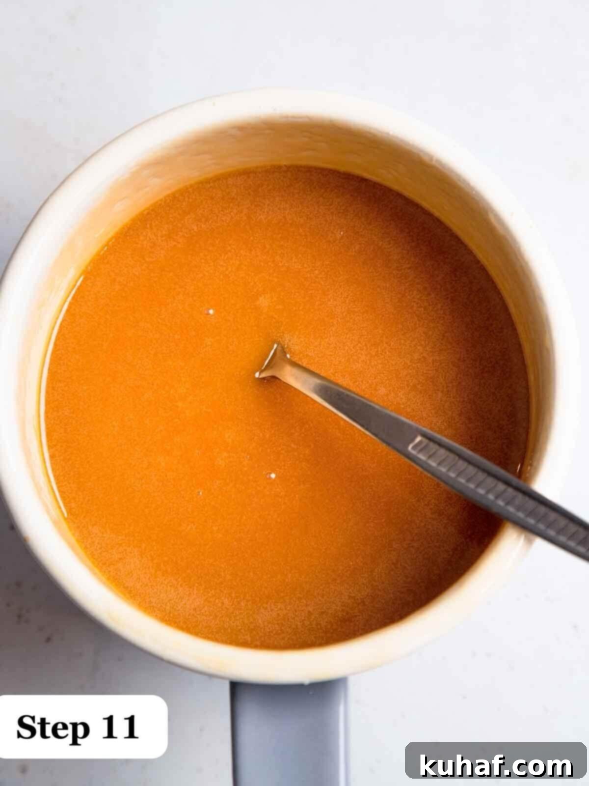 Step 11: A pristine white bowl filled with rich, glossy homemade salted caramel sauce, ready to top the pie.