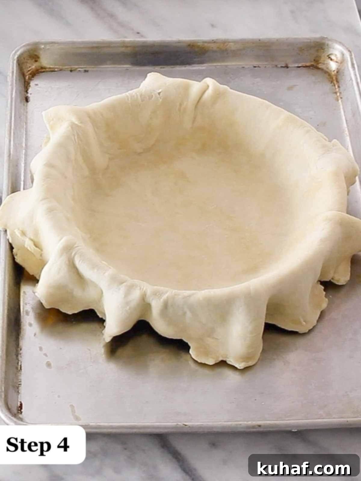 Step 4: Draping the pie crust into the pie dish, ensuring an even and neat fit.