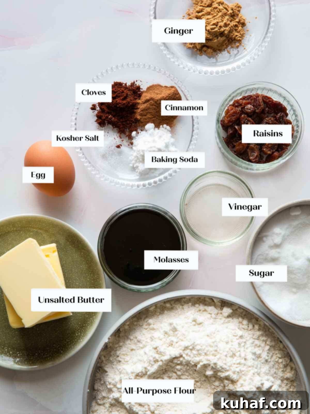 A selection of high-quality ingredients laid out for making gingerbread cookies, including spices, molasses, butter, and flour.