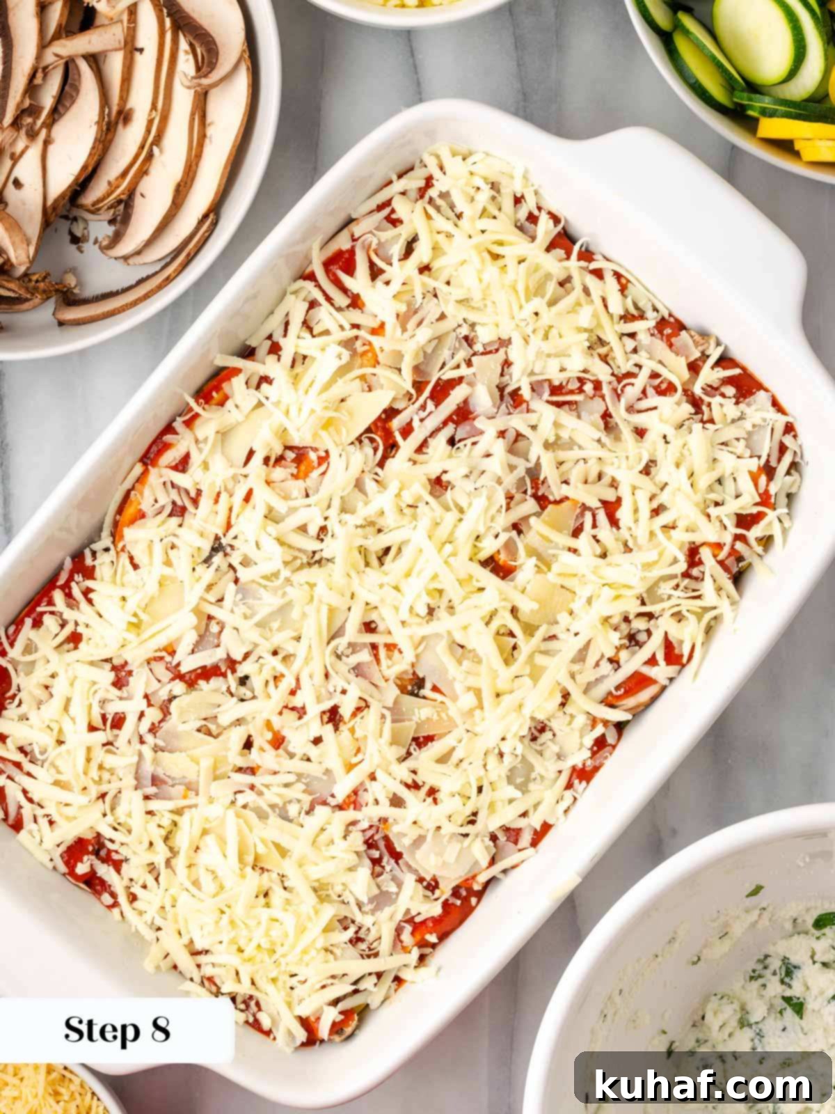 The top layer of lasagna generously covered with mozzarella and parmesan cheese, ready for baking.