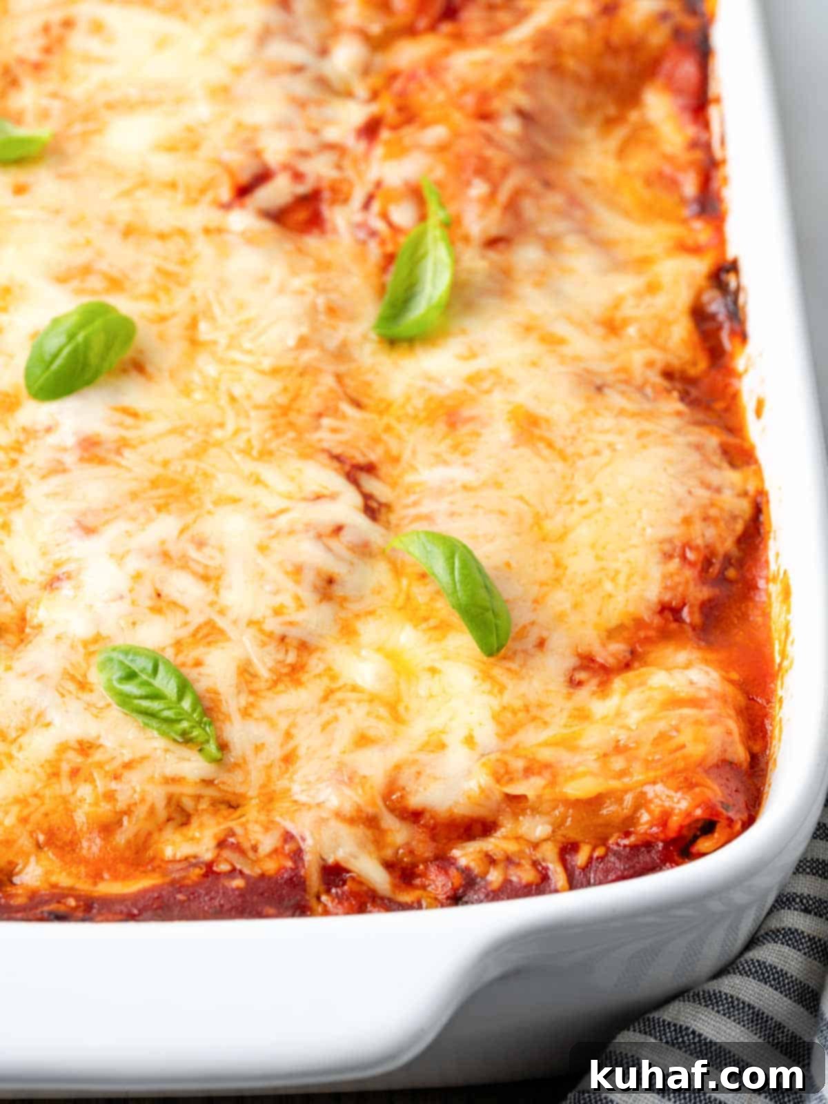 A freshly baked vegetable lasagna bubbling hot in a baking dish, with the cheese beautifully melted and golden, indicating it's just out of the oven.