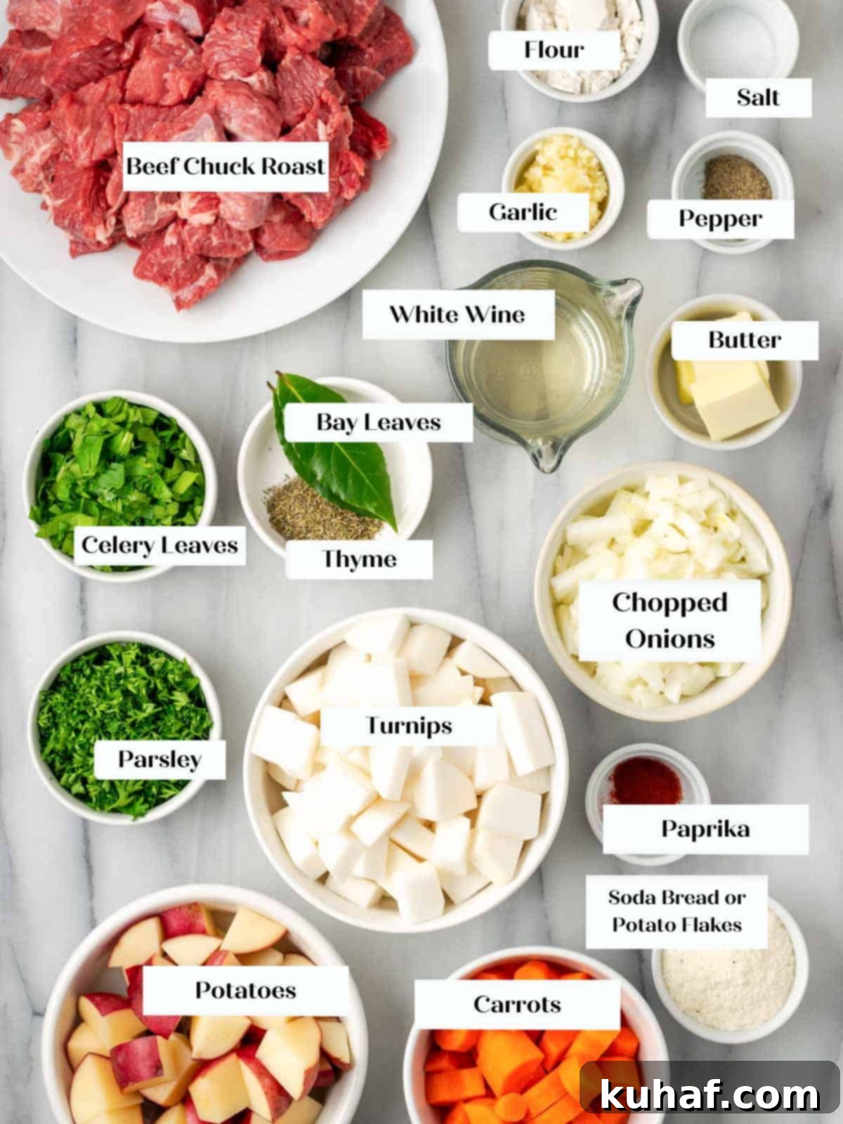 Various beef stew ingredients arranged on a marble surface, including meat, vegetables, and herbs.