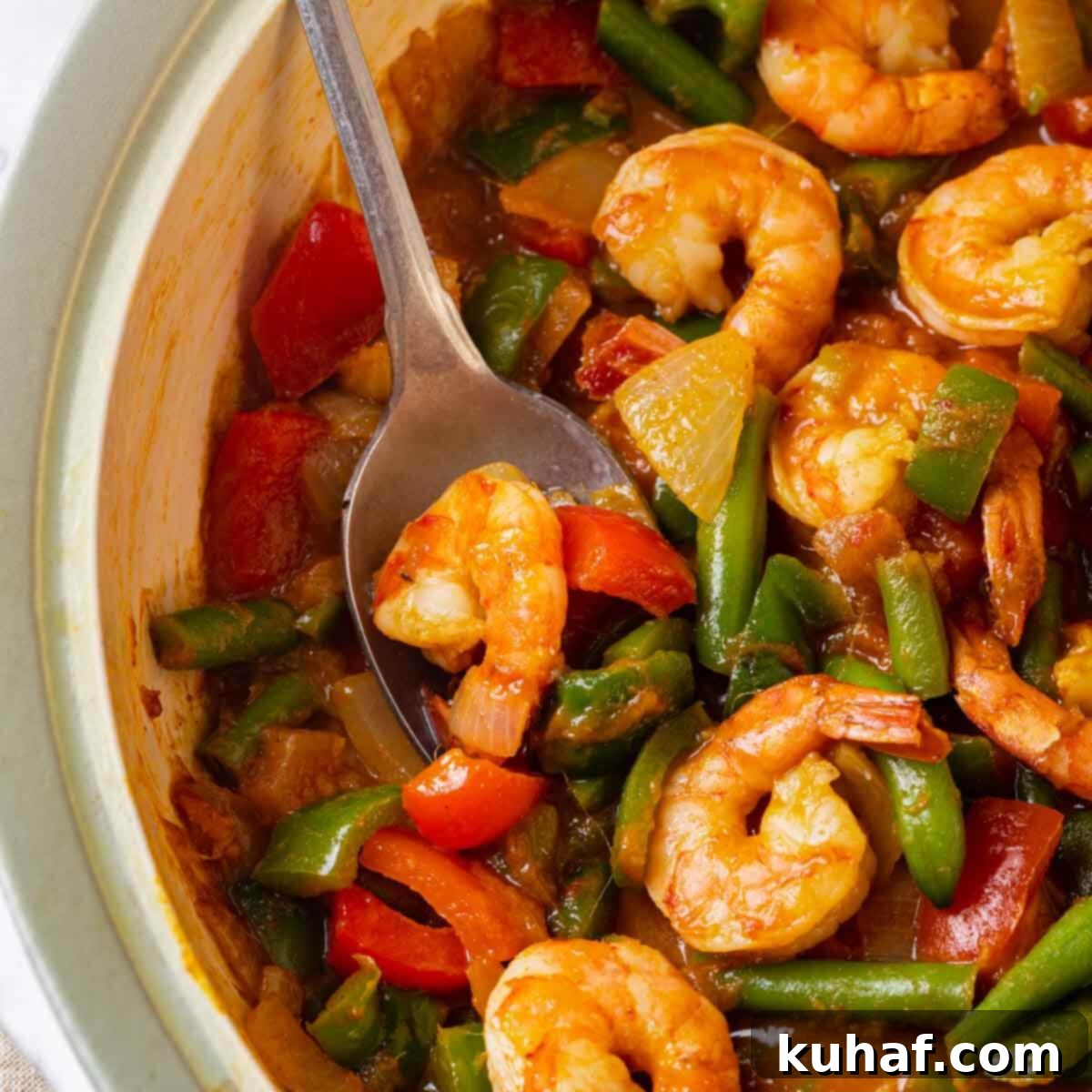 Close-up of perfectly cooked shrimp in a rich curry sauce, ready to be served.