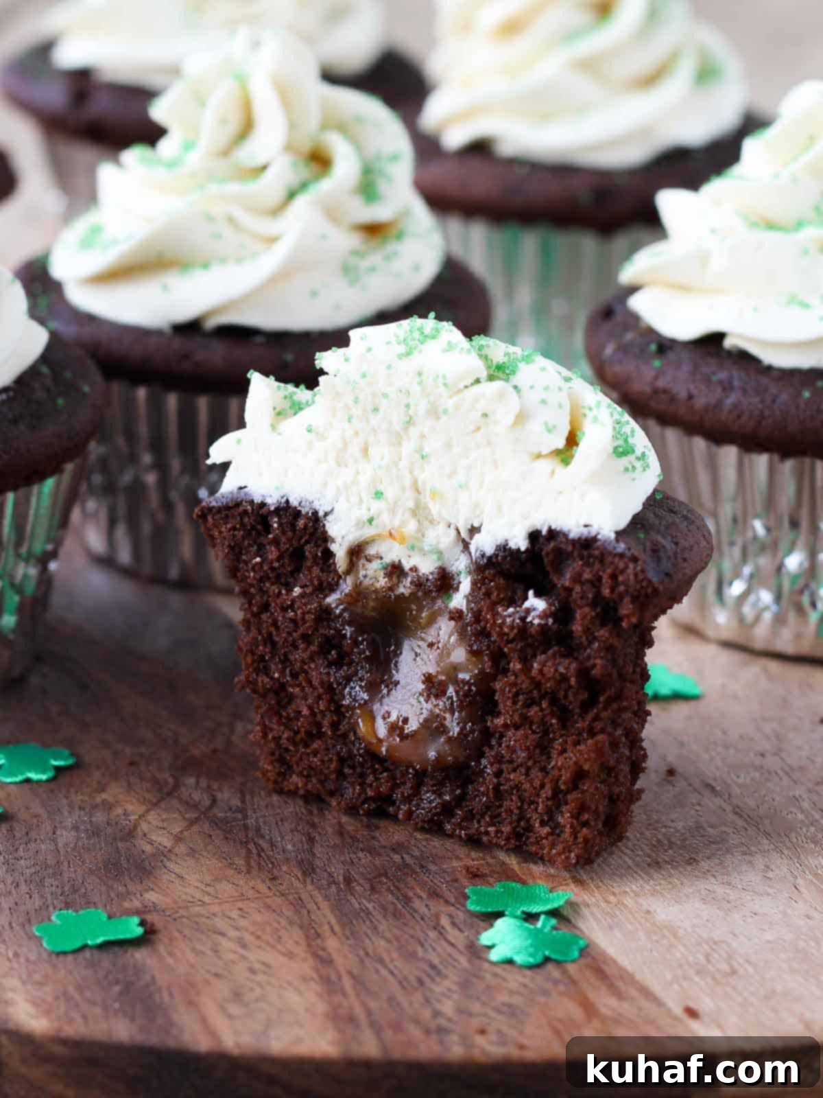 Shamrock Celebration Cupcakes 11 A freshly baked Guinness chocolate cupcake, beautifully sliced in half, revealing the generous salted caramel filling oozing from its center, ready for frosting.