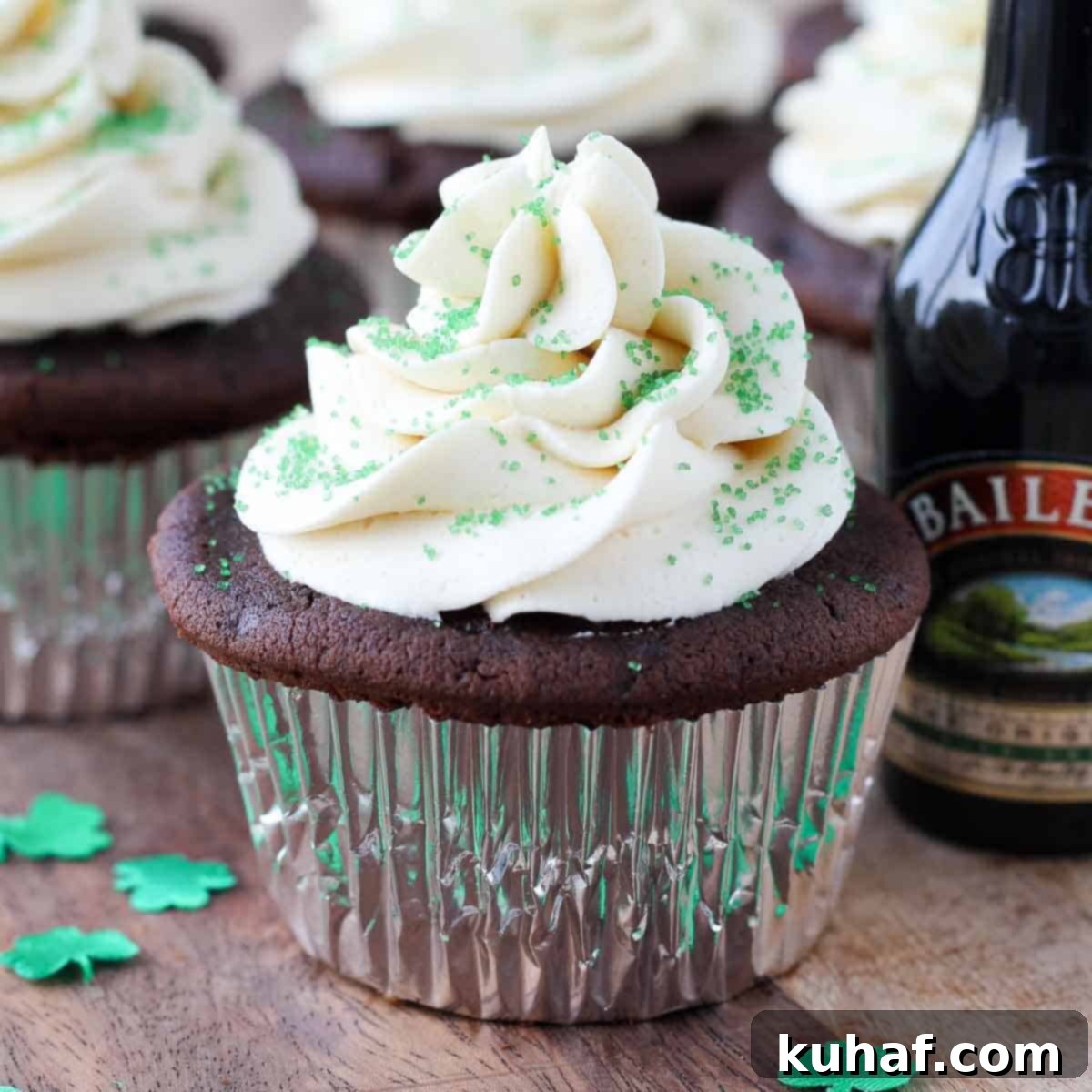 Shamrock Celebration Cupcakes 3 Festive St. Patrick's Day cupcakes arranged artfully in front of a bottle of Baileys Irish Cream, showcasing the perfect pairing.