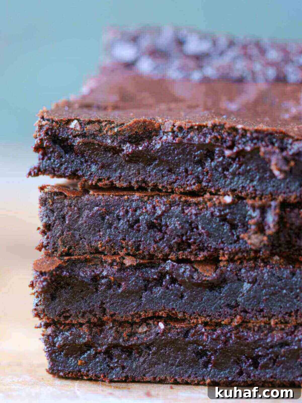 A stack of perfectly baked, fudgy one-bowl brownies with a flaky top, ready to be enjoyed.