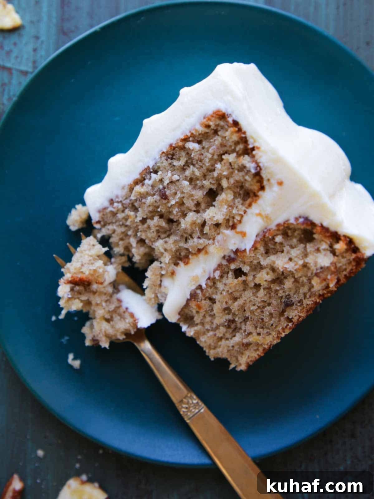 A beautiful slice of hummingbird cake on a teal plate, showcasing its moist layers and creamy frosting.