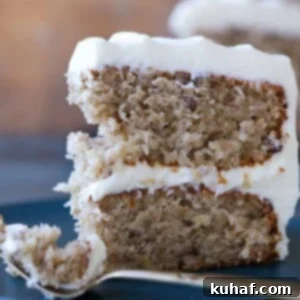 A two-layer slice of classic hummingbird cake, showcasing its moist texture and rich frosting.