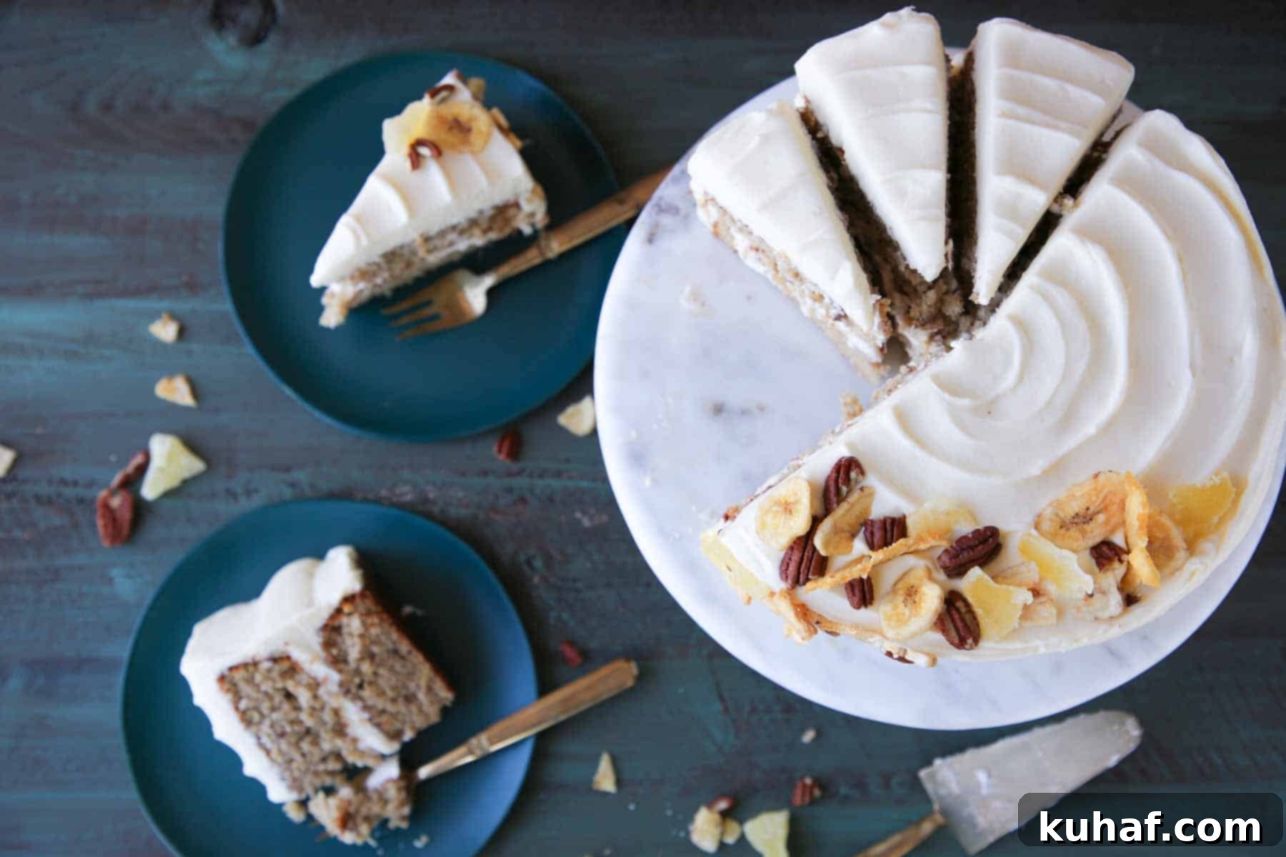 Two slices of hummingbird cake artfully arranged on a plate next to a larger sliced cake on a marble cake stand, inviting a taste.