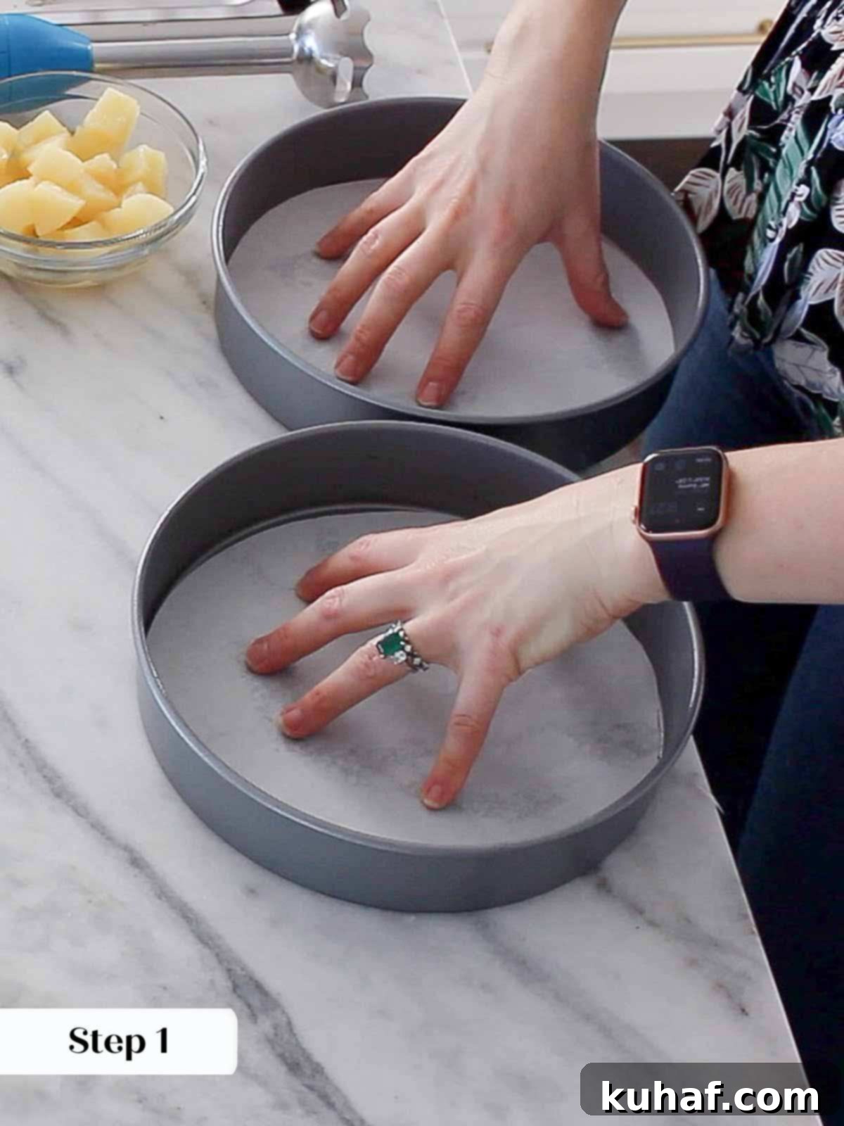 A prepared cake pan, showing the sides sprayed and the bottom lined with a parchment paper circle, ready for batter.
