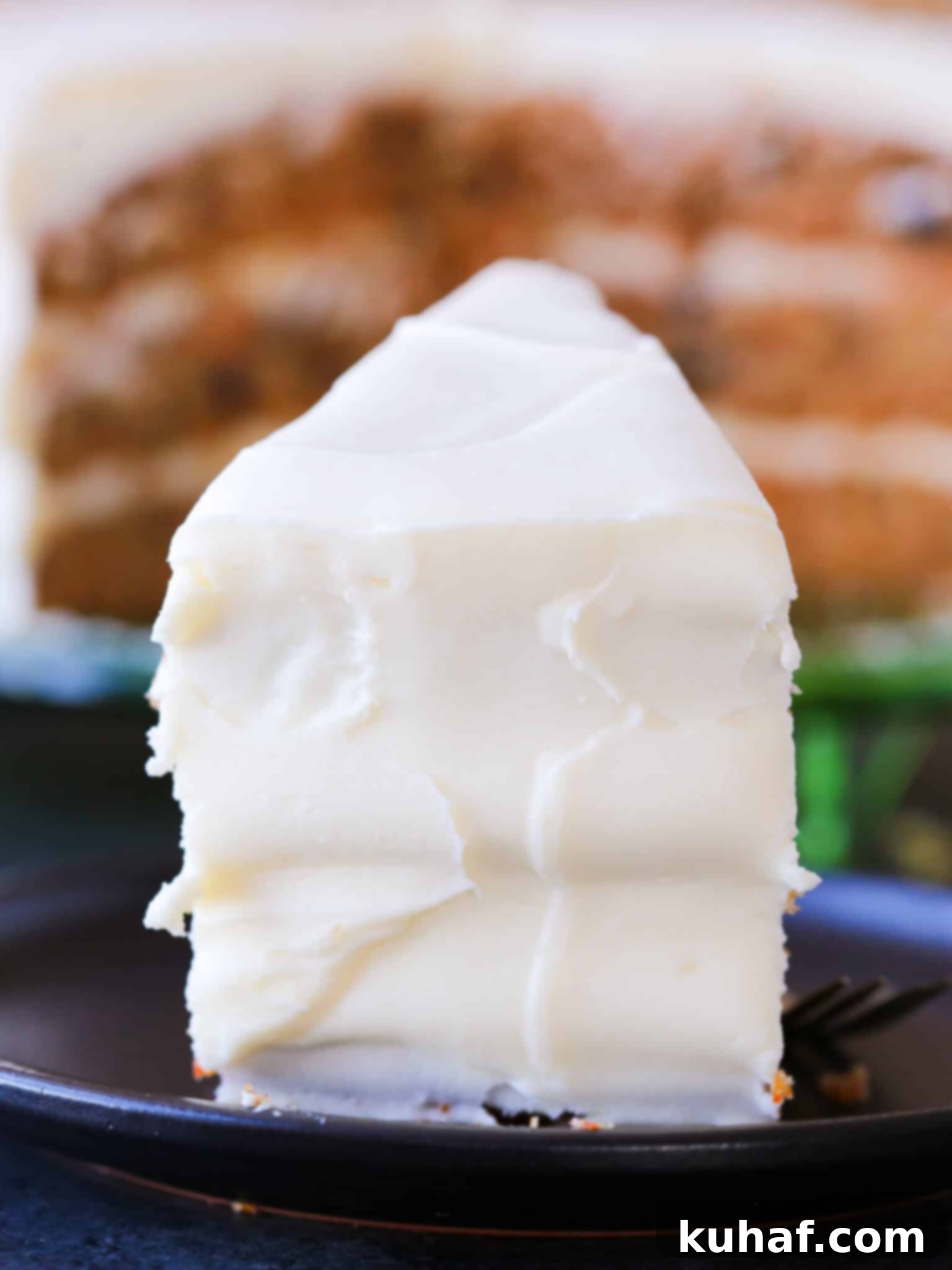 A smooth, perfectly frosted slice of easy carrot cake, ready for a bite.