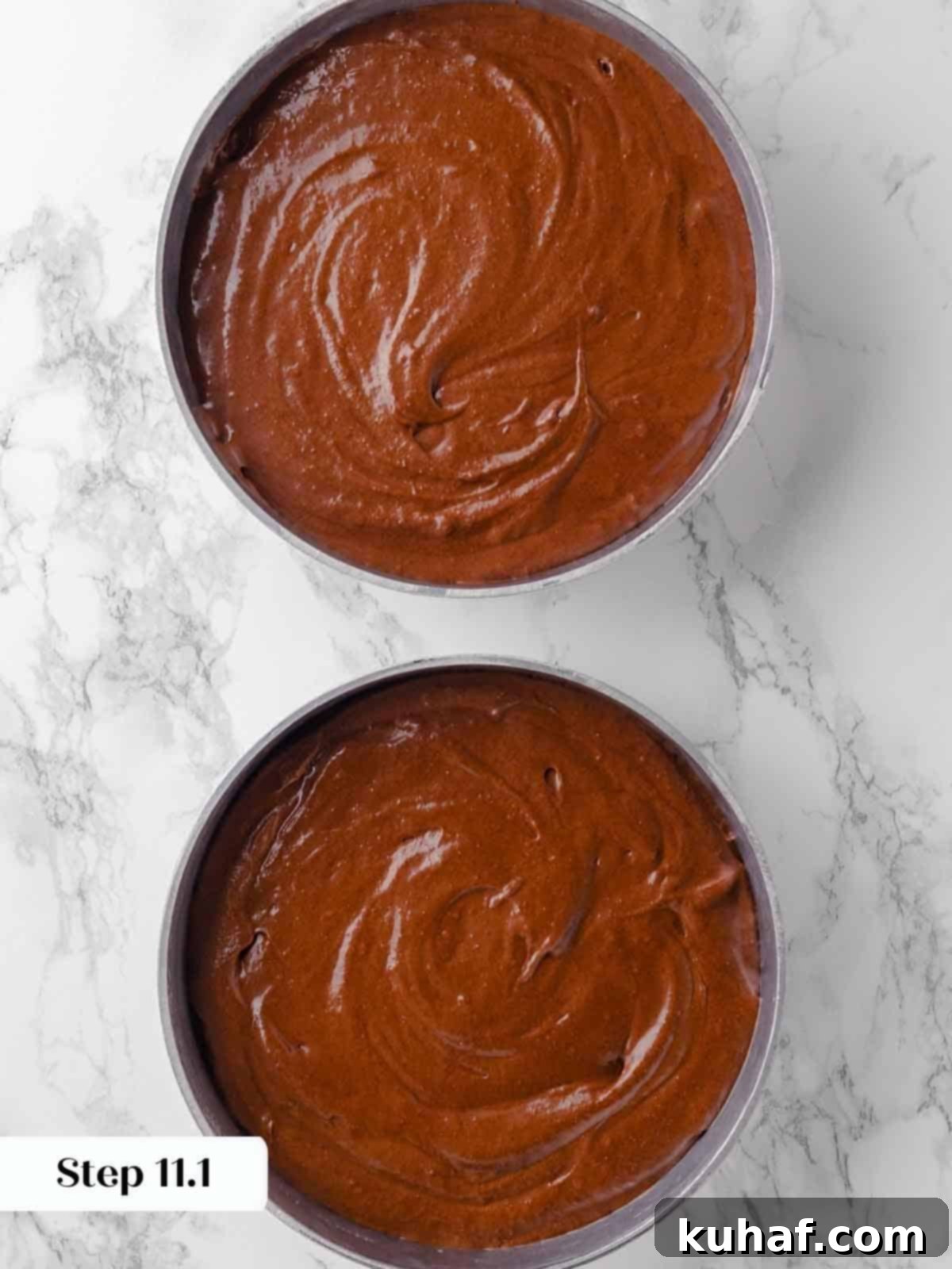 guinness chocolate cake batter divided between two prepared pans.