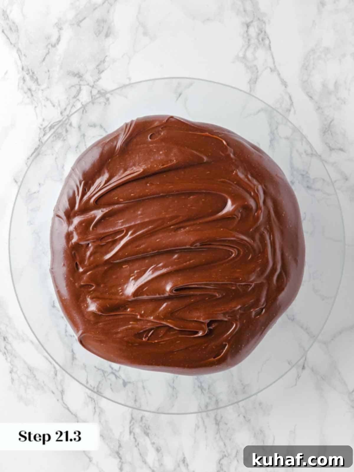 spreading frosting between layers of guinness chocolate cake during assembly.