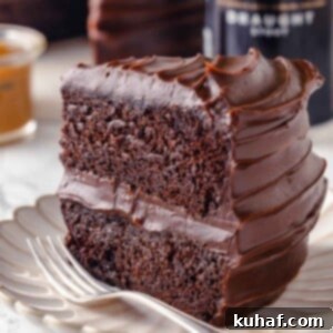 slice of guinness chocolate cake with two layers on plate with fork.