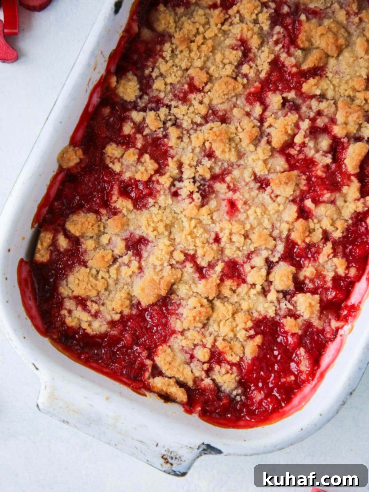 Full white baking dish of strawberry rhubarb crumble fresh from the oven.