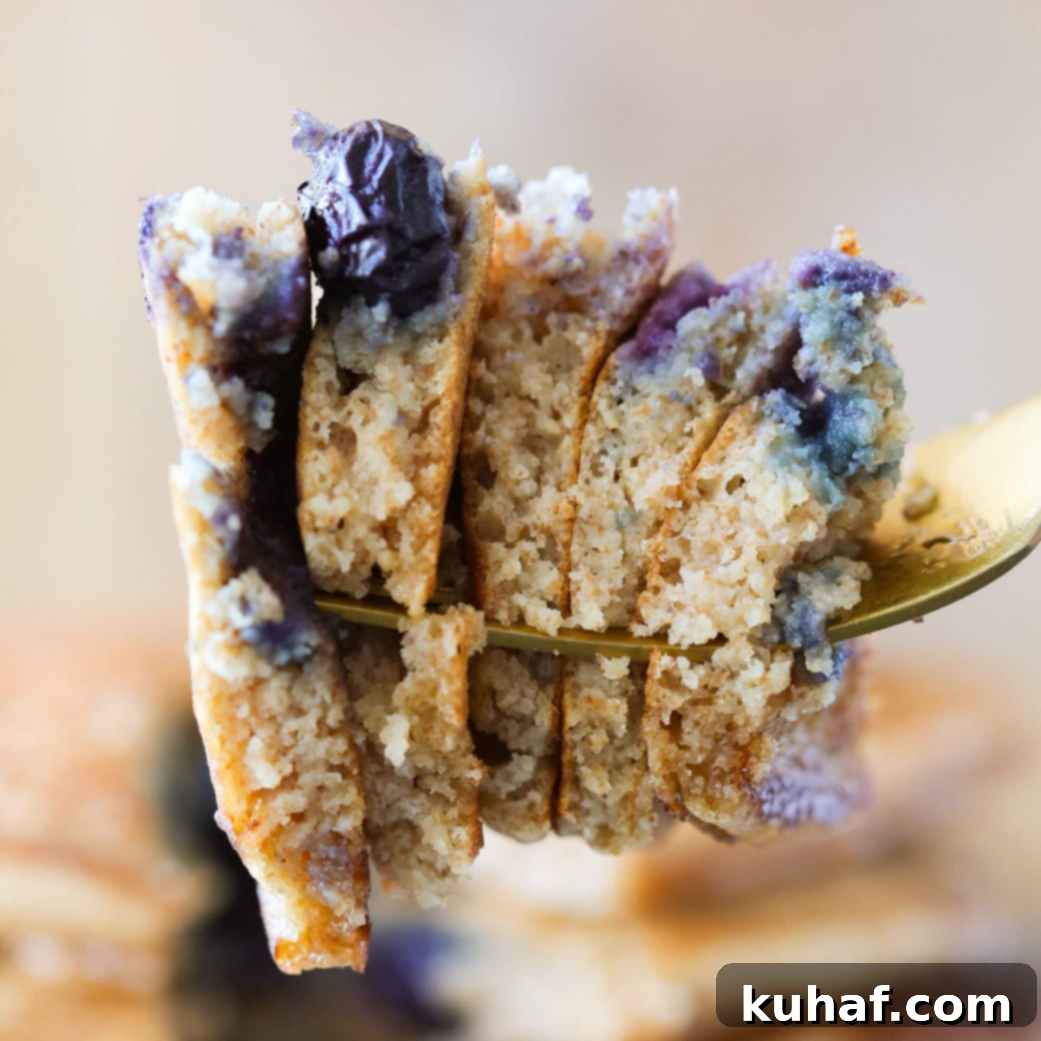 A serving of whole wheat pancakes with fresh blueberries and a generous pour of maple syrup.