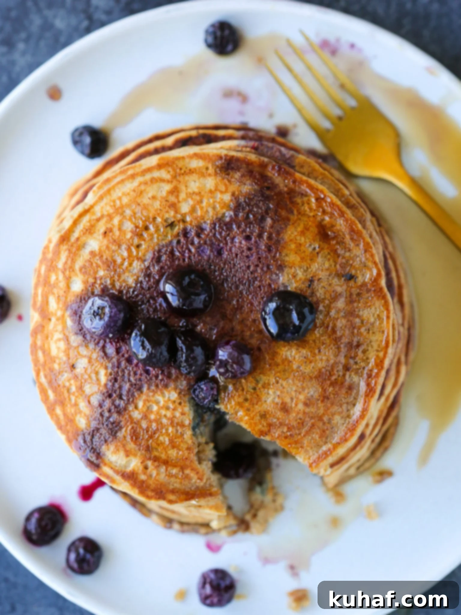 A stack of golden whole wheat pancakes, seen from the side, revealing their fluffy texture.