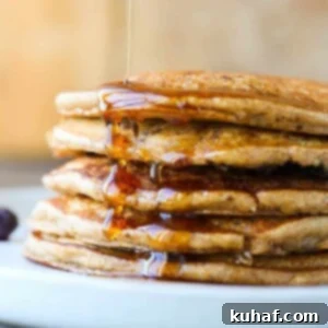 Whole wheat pancakes stacked with maple syrup