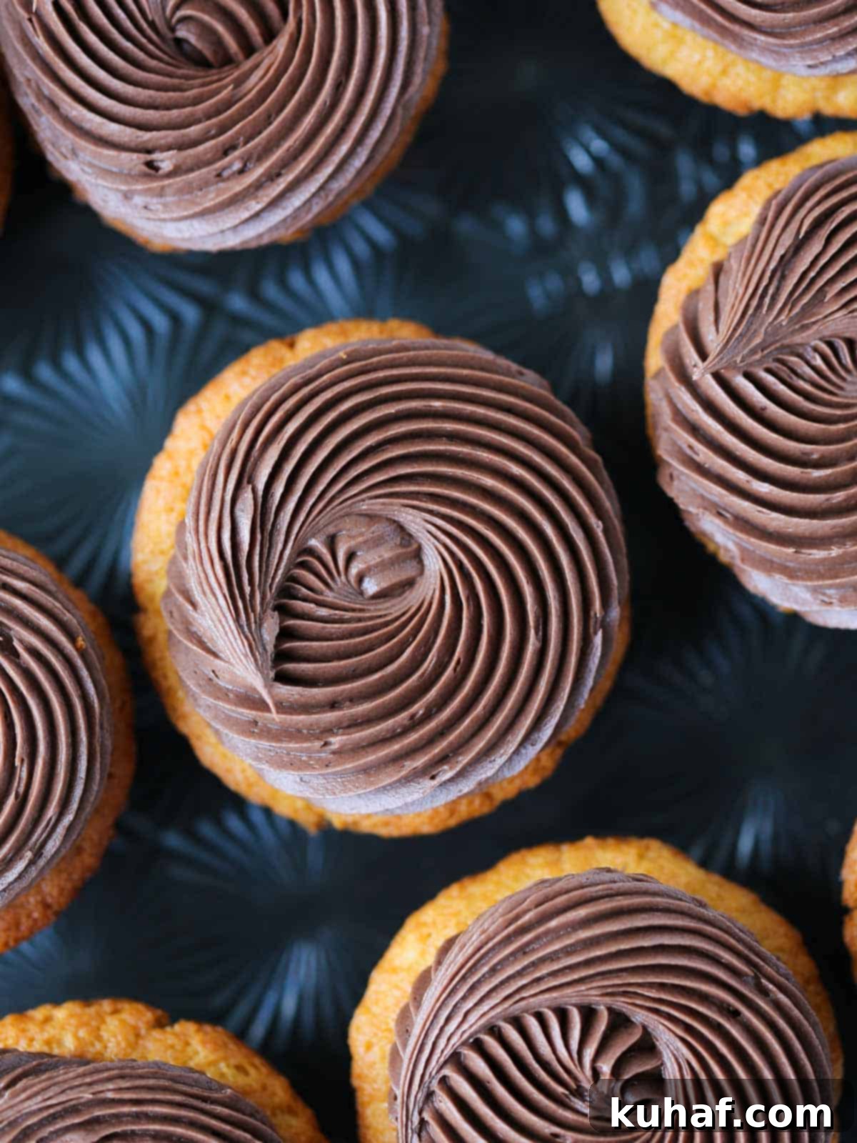 Decadent Chocolate Caramel Cupcakes 2 swirls of chocolate butter cream on cupcakes black background.