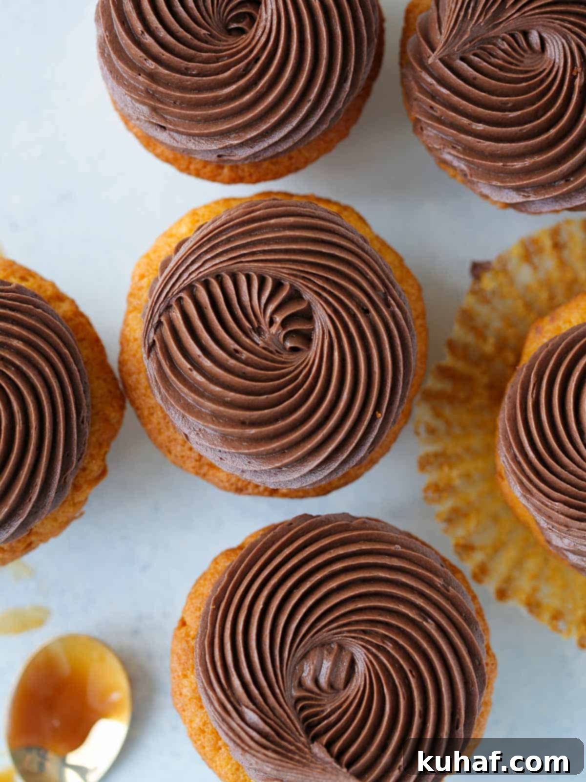 Decadent Chocolate Caramel Cupcakes 4 swirls of chocolate butter cream on cupcakes blue background.
