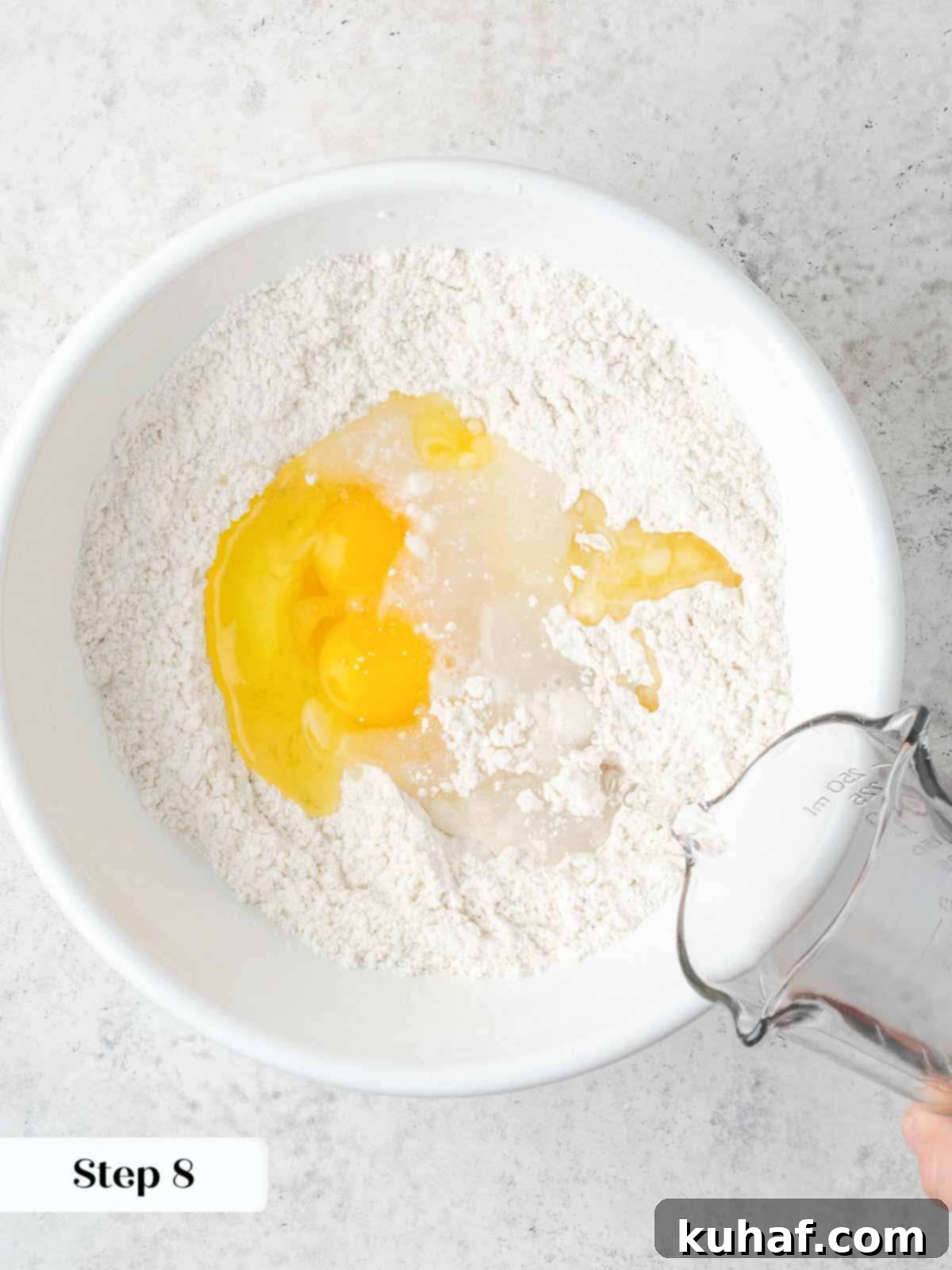 Dry ingredients (flour and salt) whisked in a bowl with a well created for wet ingredients.
