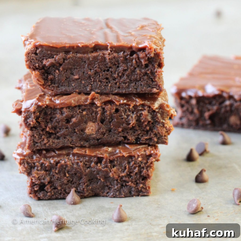 Close-up of a stack of fudgy milk chocolate brownies with glistening ganache, ready to be served