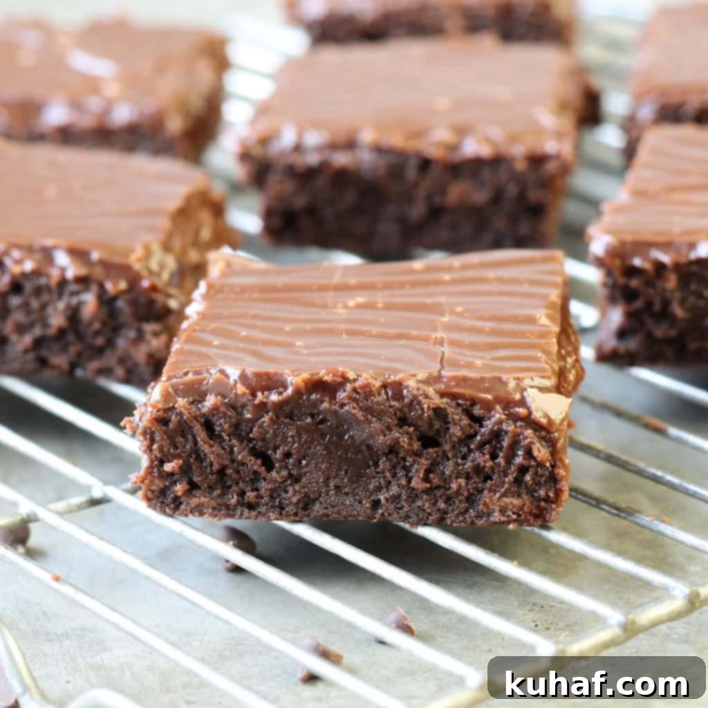 A single piece of fudgy milk chocolate brownie with a thick layer of ganache on a plate
