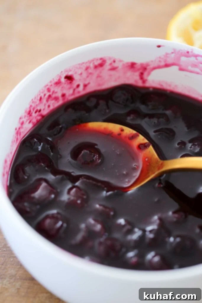 A spoonful of glistening easy blueberry sauce ready to top a dessert.