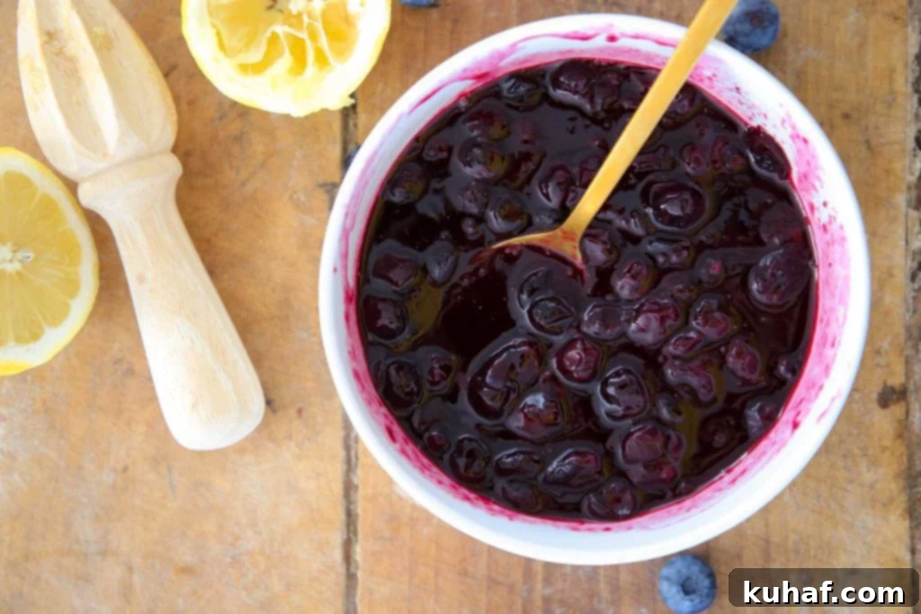 Fresh lemons next to a bowl of blueberry sauce, hinting at the tangy flavor profile.