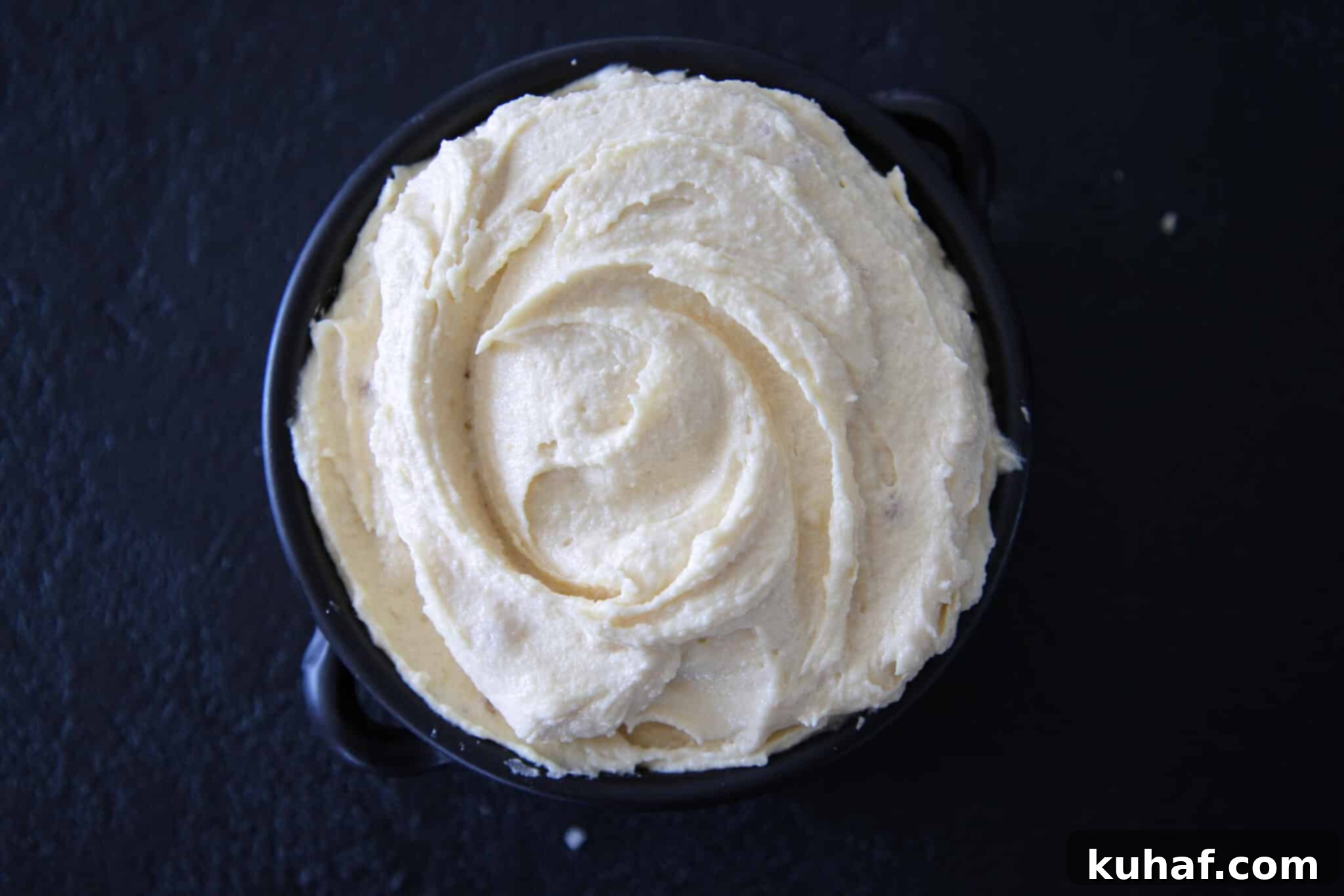 Rich and creamy almond cream with almond paste, showcased against a elegant black backdrop.
