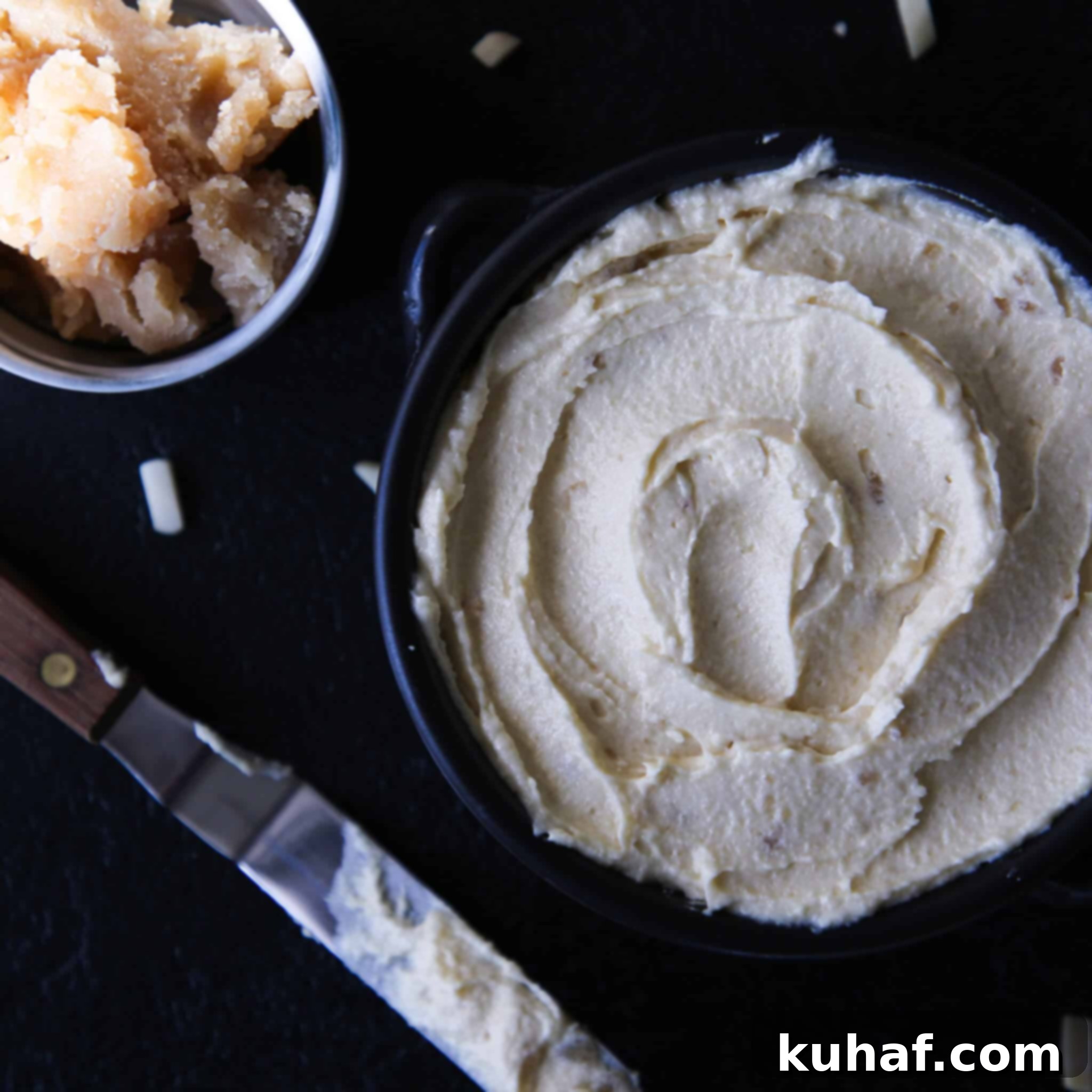 Creamy almond cream with almond paste being scooped by a knife, showcasing its smooth texture.
