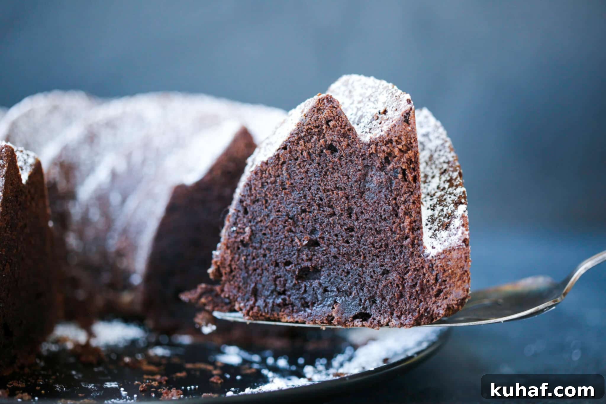A slice of chocolate pound cake on a vintage cake server.