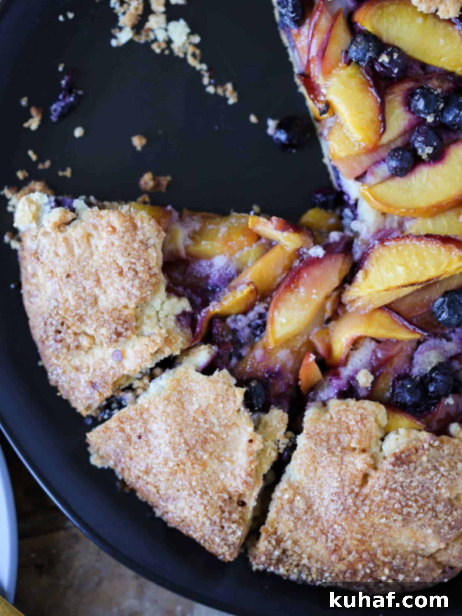 A delicious slice of Nectarine Blueberry Galette on a white plate, showing the tender crust and fruit filling.