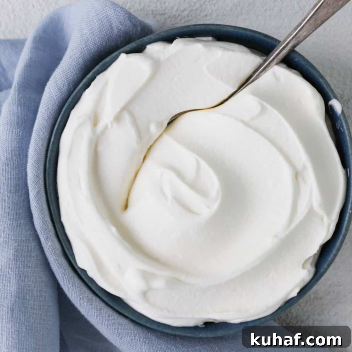 Close-up of a perfect swirl of homemade whipped cream, showcasing its smooth, airy texture and professional quality.