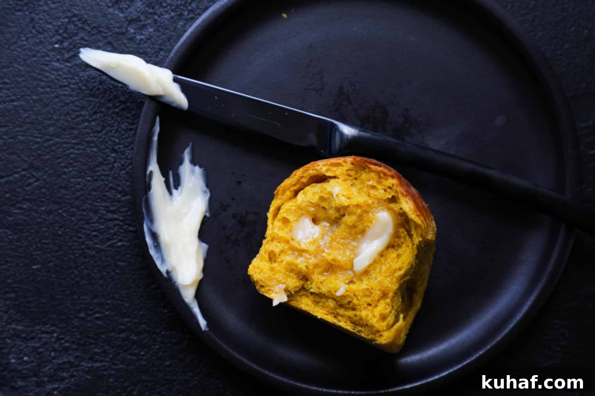 Artisan Maple Butter 3 Homemade Maple Butter generously spread on a warm pumpkin spice roll, showcasing its creamy texture and inviting aroma.