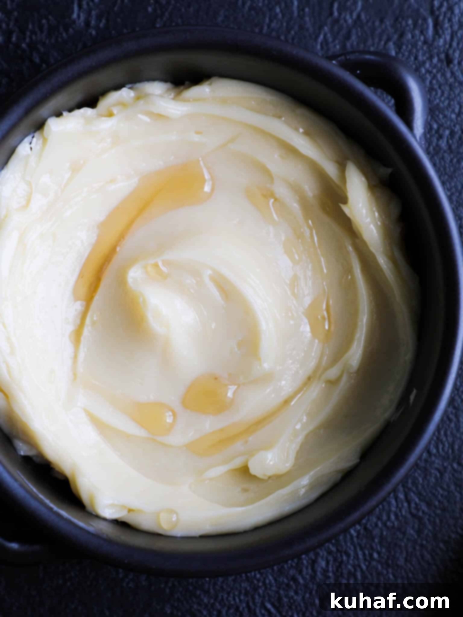 Artisan Maple Butter 4 Homemade Maple Butter in a glass jar, with dark shadows, showcasing its rich texture and inviting golden hue.