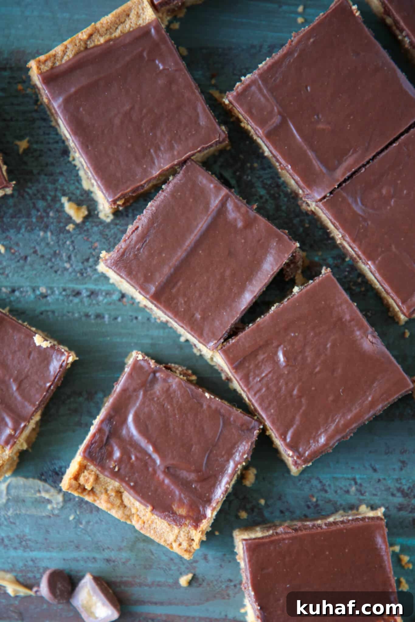 Perfectly cut Fudgy Peanut Butter Reeses Chocolate Bars on a vibrant turquoise surface
