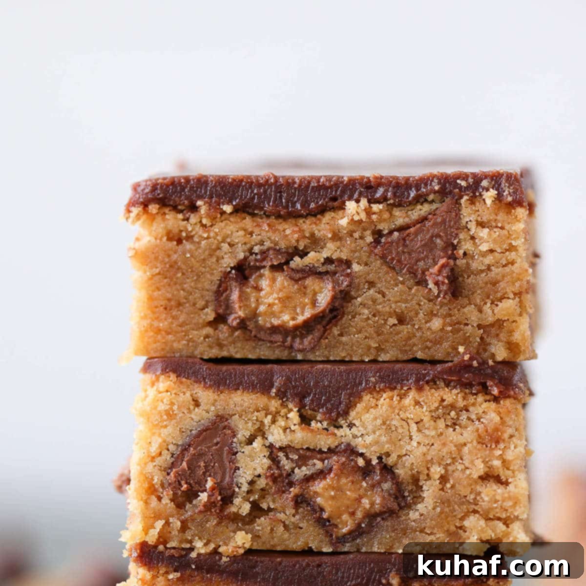 Close-up of Fudgy Peanut Butter Reeses Chocolate Bars revealing the dense, chewy interior with chocolate chips and Reese's pieces
