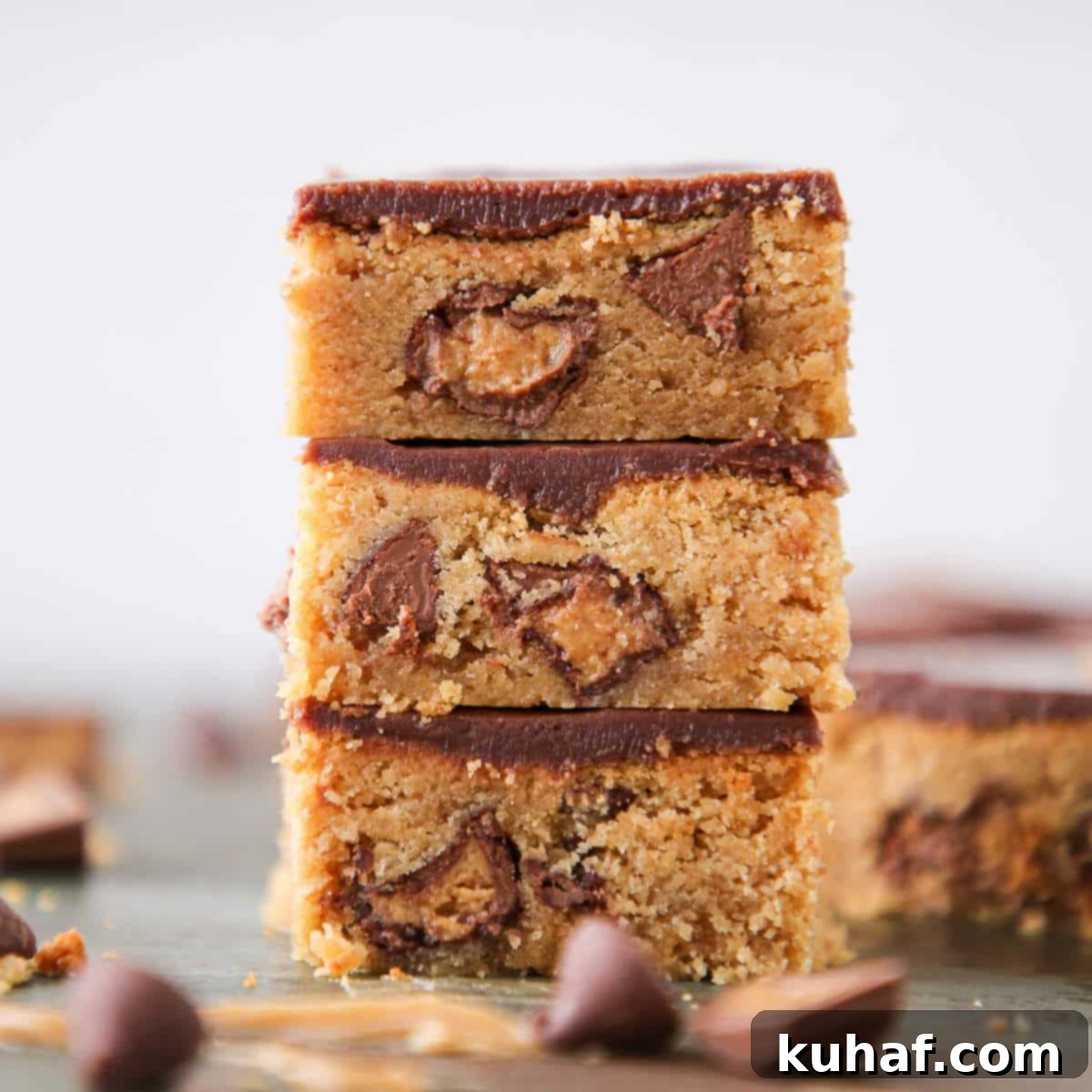 Three Fudgy Peanut Butter Reeses Chocolate Bars stacked neatly, showing off their layers