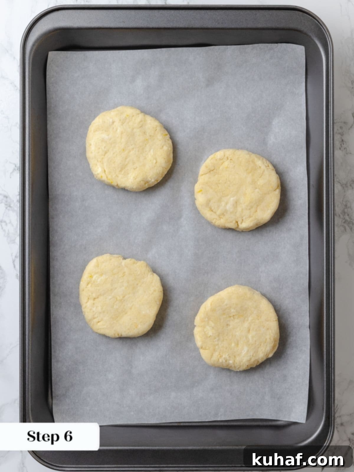Strawberry Shortcake Solo 11 Biscuit dough rounds on a parchment-lined baking sheet after chilling, brushed with cream and sprinkled with sugar.