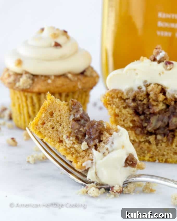 cupcake sliced open on fork white background - an indulgent pumpkin pecan pie cupcake.