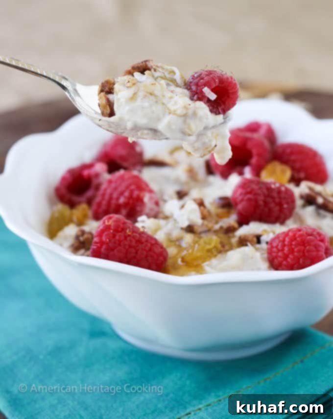 A bowl of Bircher Muesli with a variety of fresh fruits and a sprinkle of cinnamon.