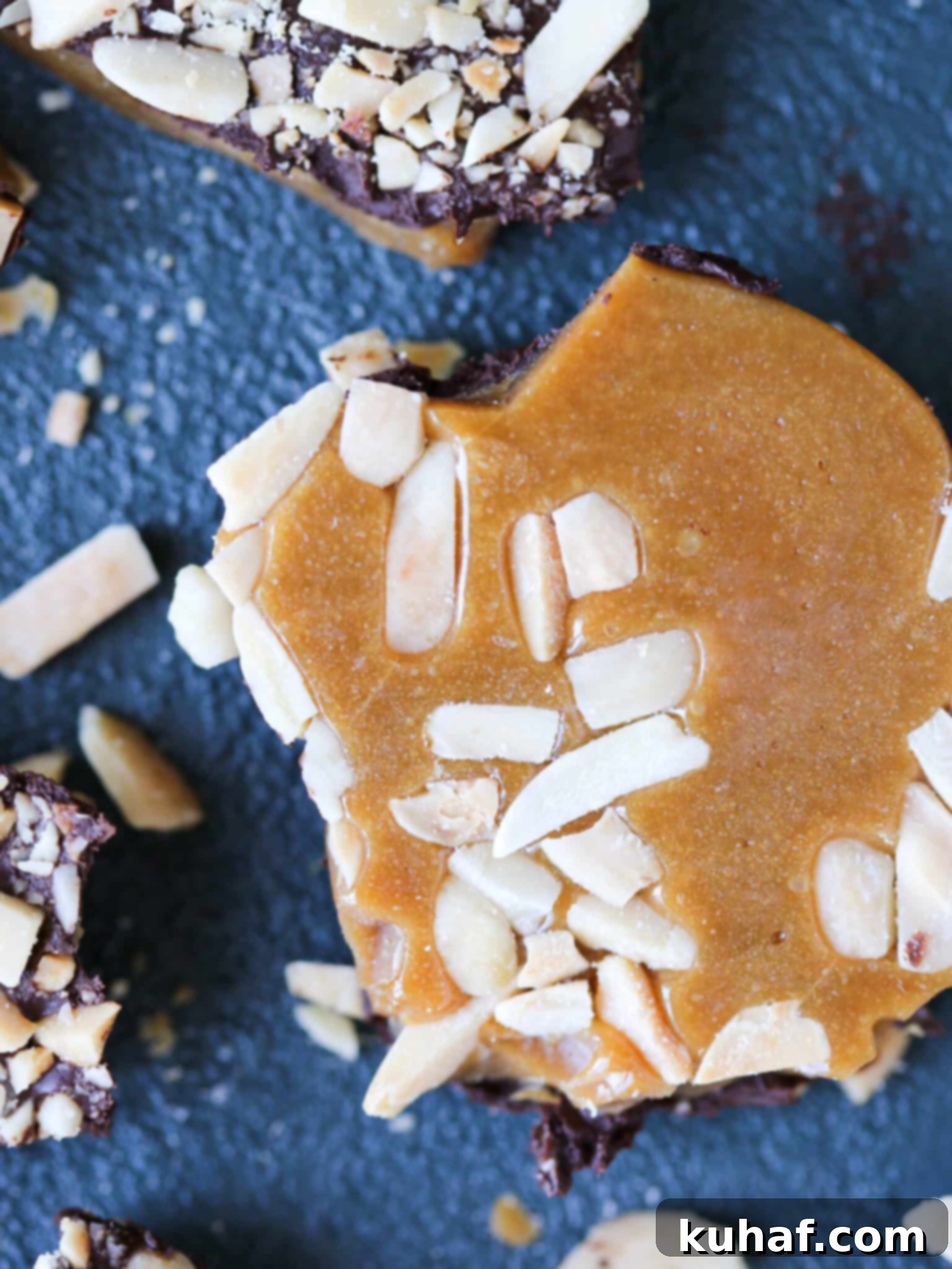 Closeup of homemade toffee with toasted almonds and chocolate drizzle