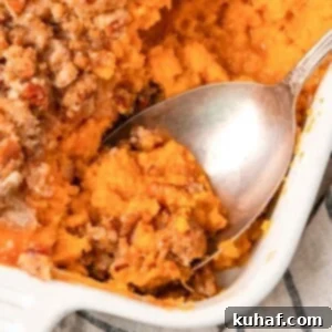 Sweet potato casserole being served with a spoon, showing its delicious layers.