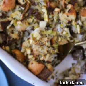 A spoonful of Apple Sage Sausage Stuffing, showing its delicious texture and ingredients.