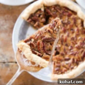 A perfectly sliced pecan pie, ready to be served, showcasing its rich, glistening filling and crisp, nutty top.