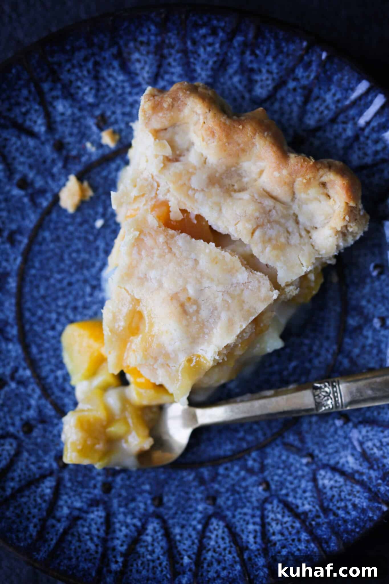 A charming slice of Old Fashioned Peach Pie, nestled in a vintage pie tin, stands out among the 20 best Thanksgiving pie recipes, inviting a taste of classic comfort.