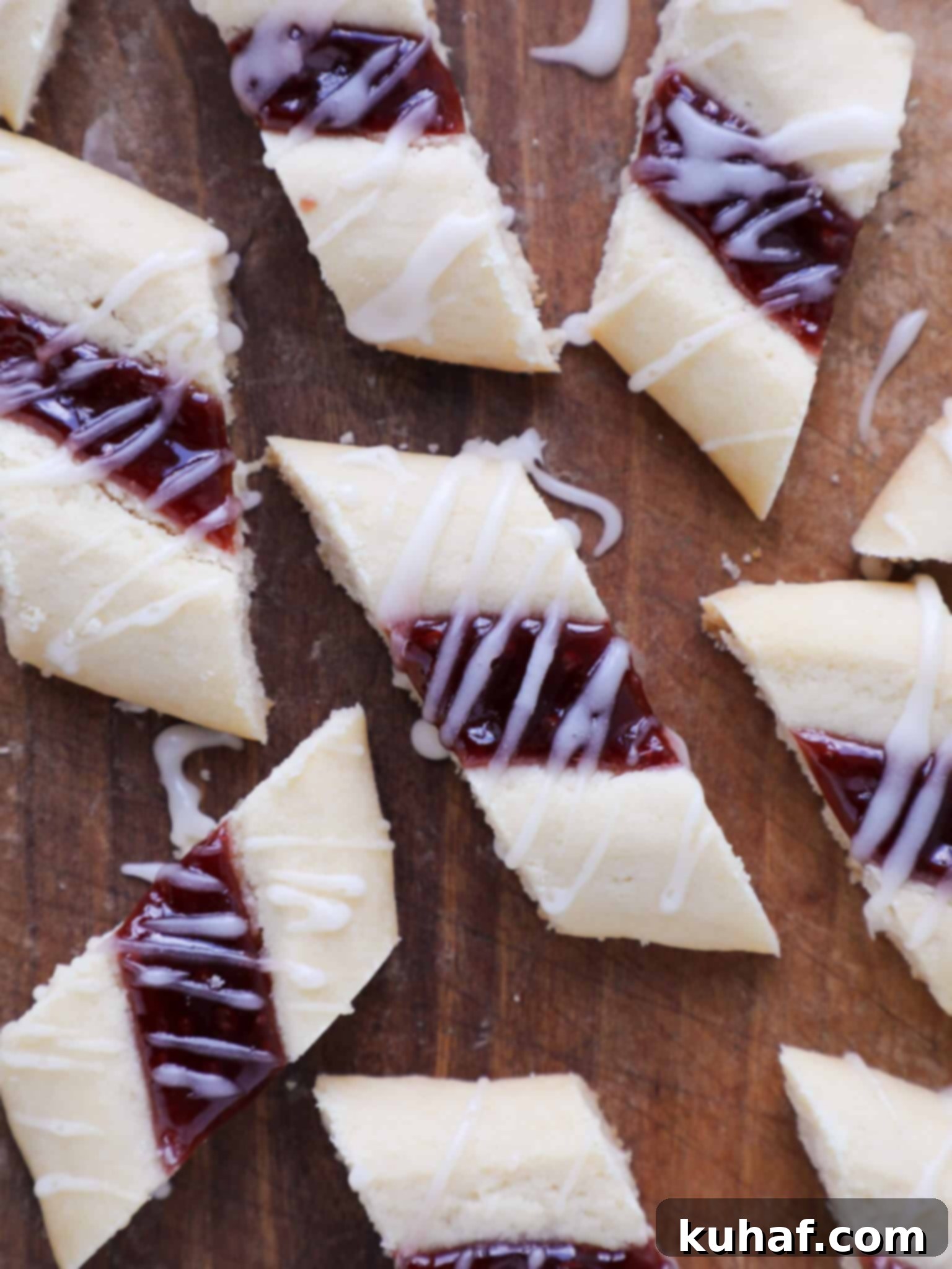 Elegant Raspberry Ribbon Cookies 2 Danish Raspberry Ribbon Cookies Drizzled Topping - A close-up of baked cookies with a vanilla glaze and raspberry jam center.
