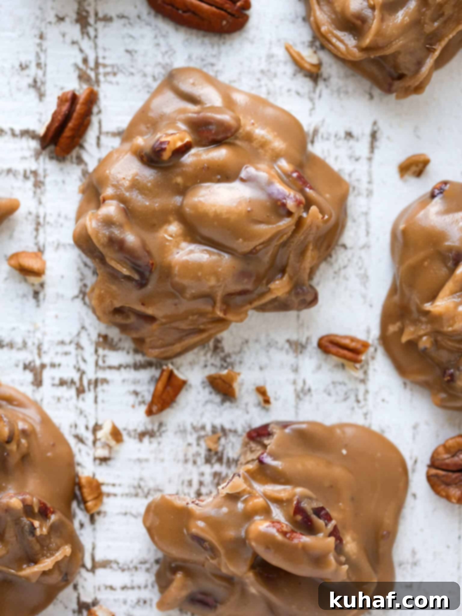 Caramel colored top of a pecan praline studded with nuts.
